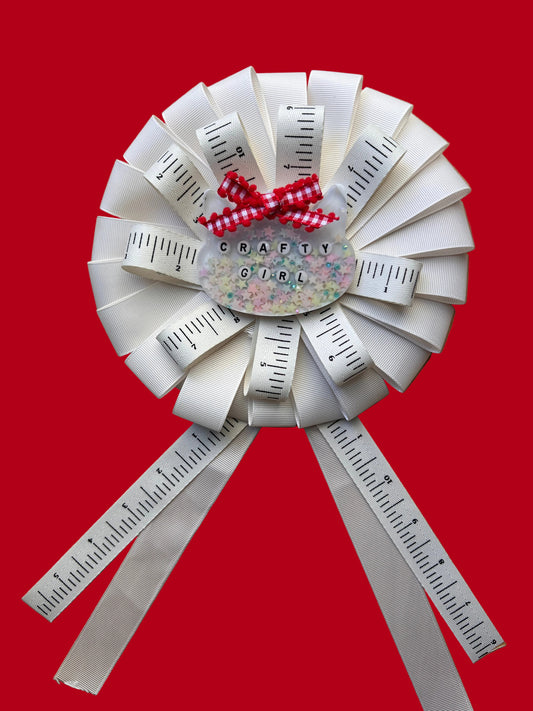 Decorative paper craft with rulers and a small round object on a wooden surface